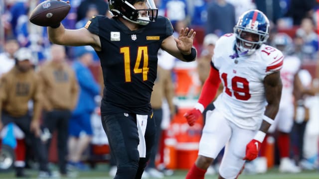 Washington Commanders quarterback Sam Howell (14) passes the ball as New York Giants wide receiver Isaiah Hodgins (18) chases during the fourth quarter at FedExField.